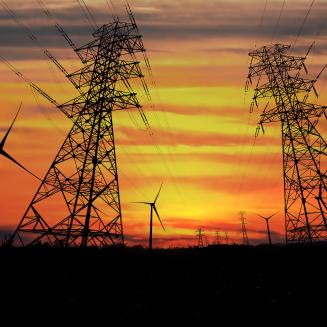 Landscape featuring electric power lines commingling with wind turbines