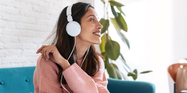 woman under headphones listening to Degrees podcast about planet-saving careers